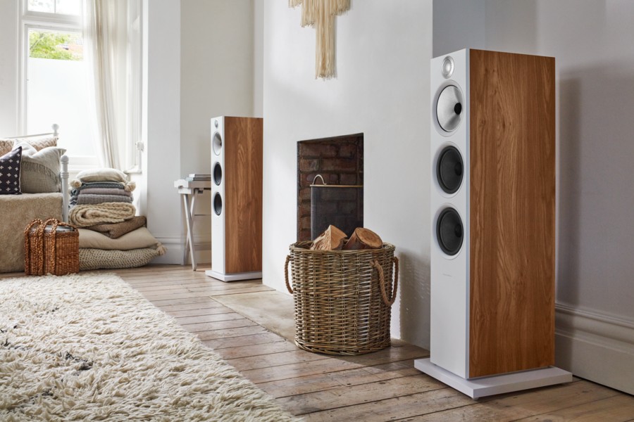 White Bowers & Wilkins loudspeakers border a fireplace in a living room. 