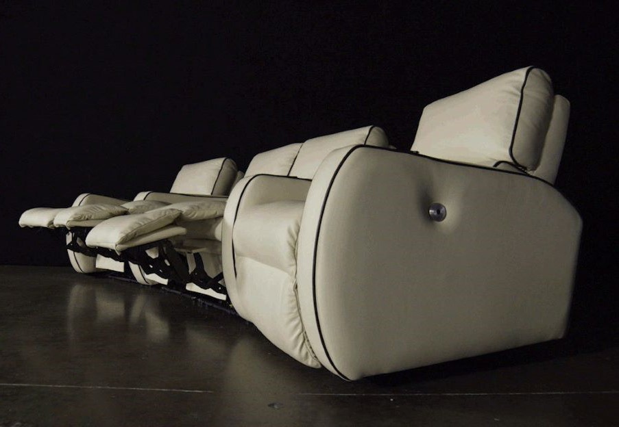 View of white power recliners against a black backdrop.