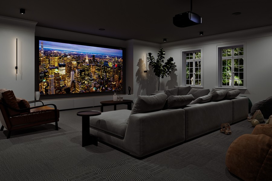 Dark theater with gray walls and carpet and lounge chairs facing a large home theater screen.