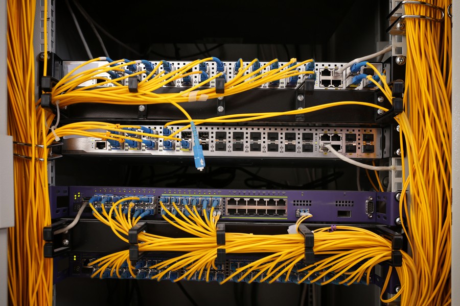 Home networking switch with various yellow ethernet cables attached.