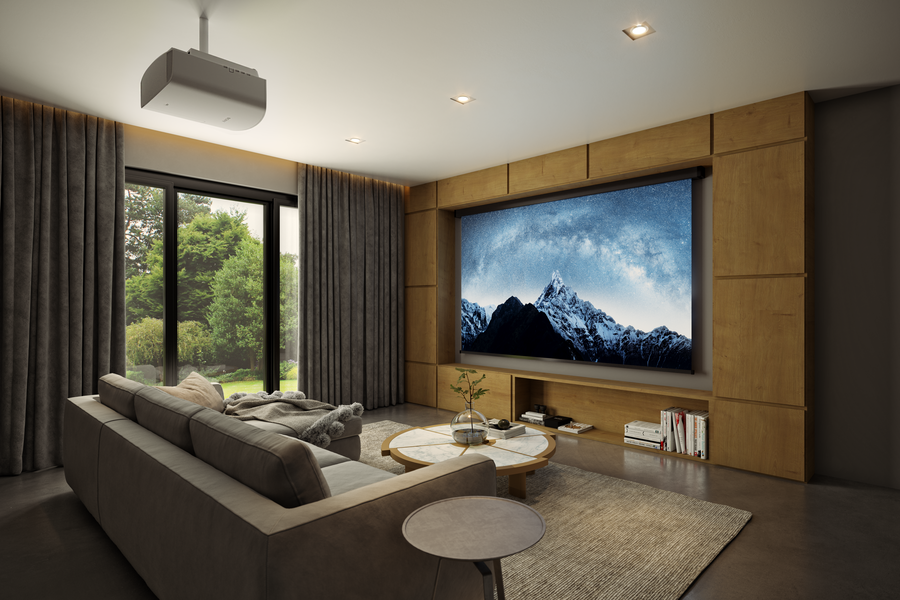 Media room with a dark gray couch looking at a large screen on a wooden wall while a floor to ceiling window looks out at a nature view.
