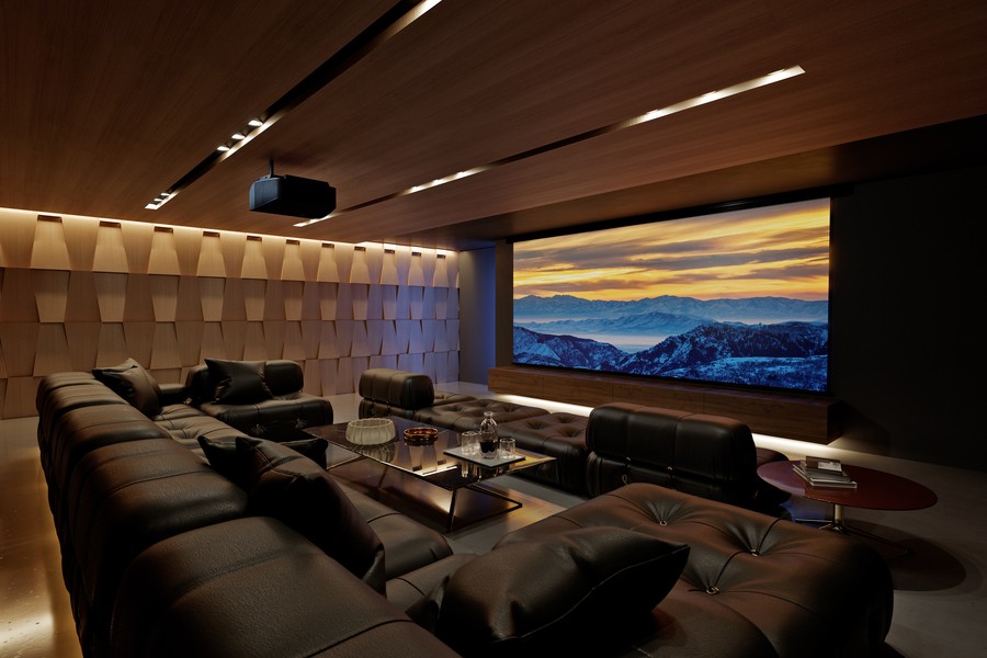 A home theater featuring light brown walls, extensive black seating, and a large theater screen.