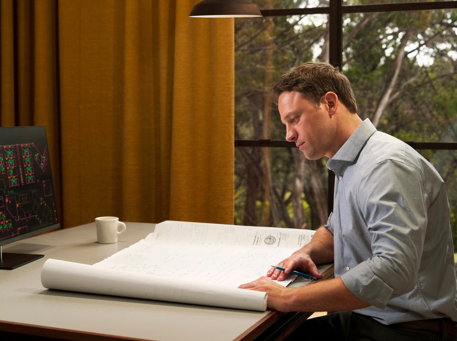 Man working in a home office under task lighting.